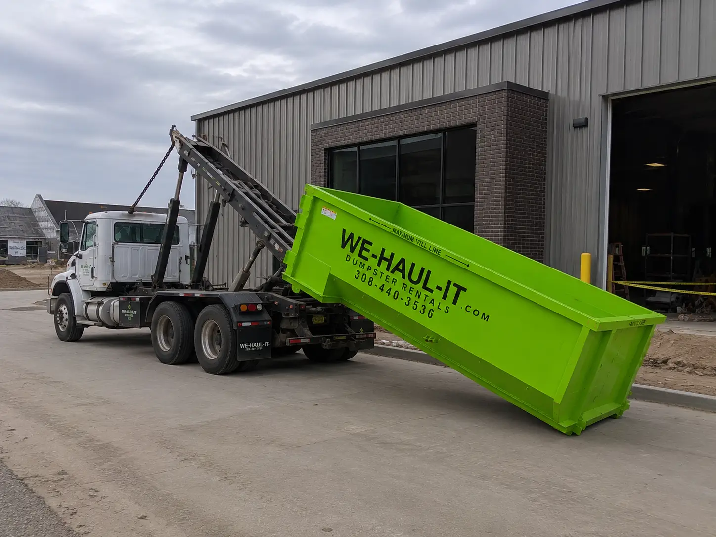WE-HAUL-IT 15 yard roll-off dumpster being placed on a Central Nebraska driveway